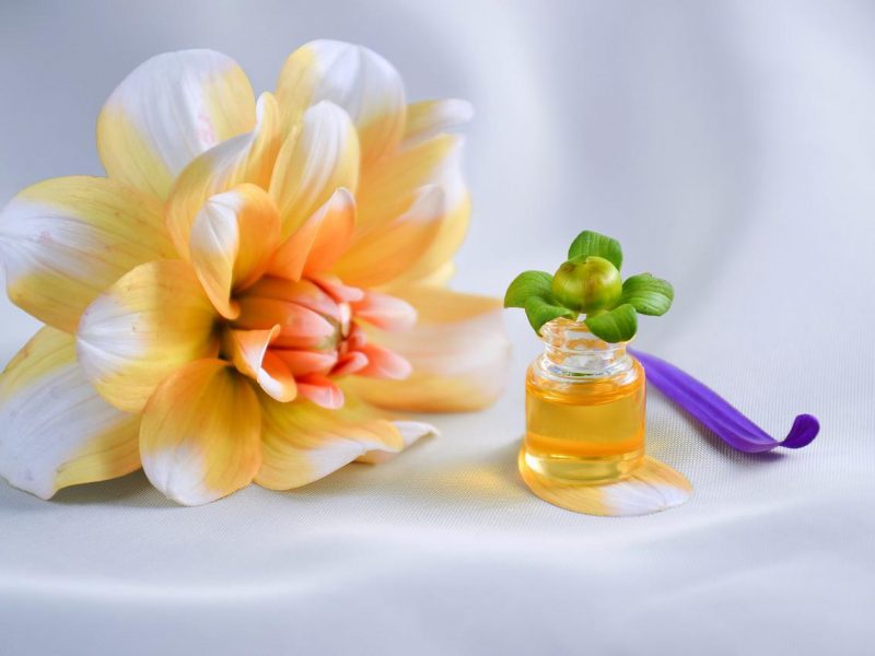 Sukshma Marma Massage Blume weiss orange gelb und kleines Fläschchen mit Massageöl